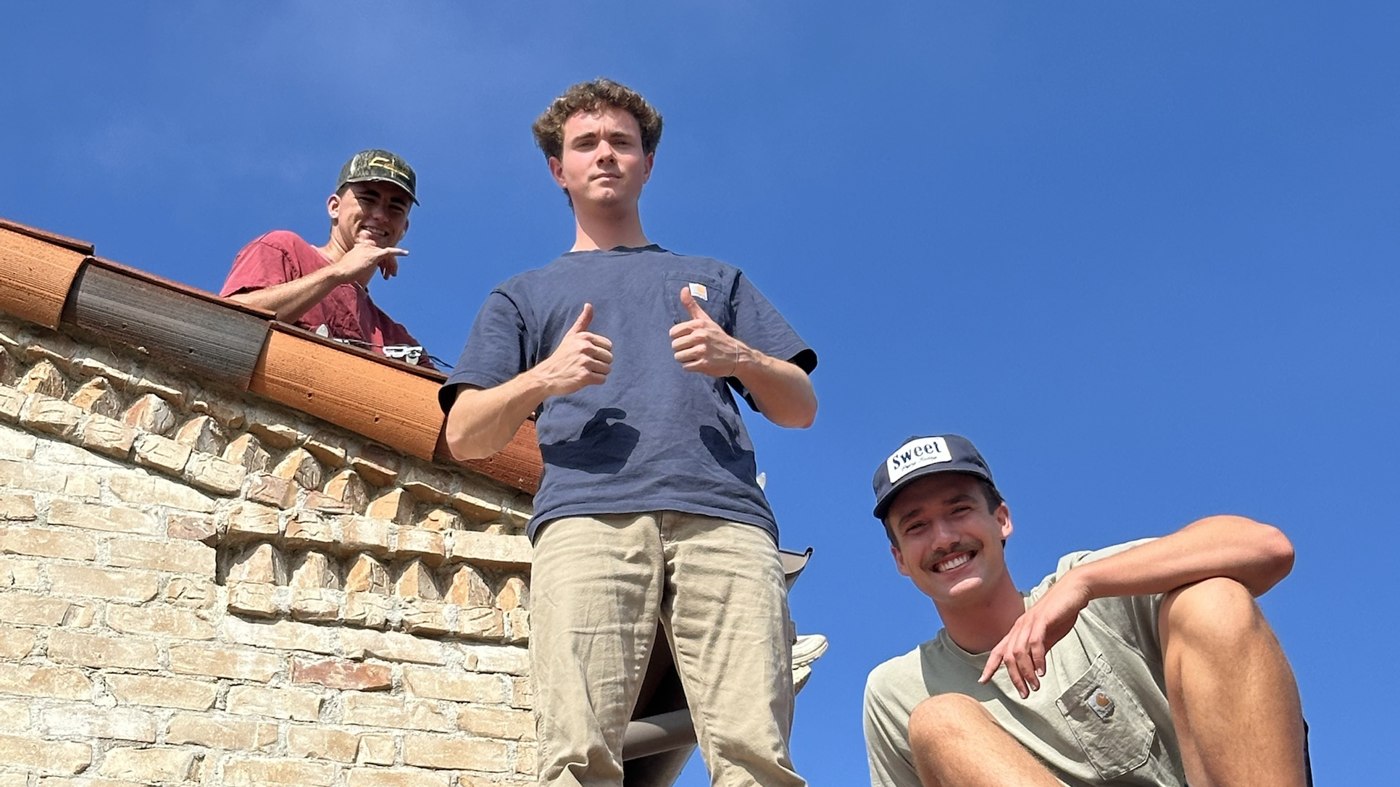 The Genesis Christmas Lights crew on a rooftop installing lights