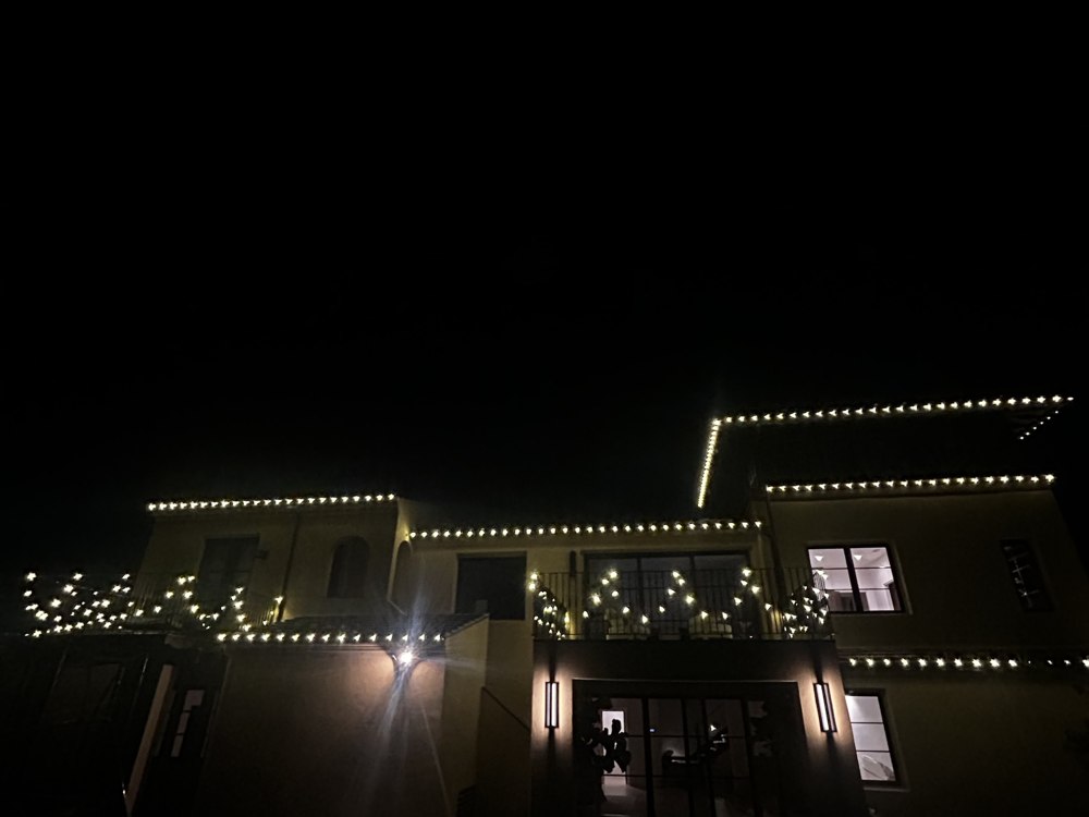 Two-story home with balcony and roofline lighting