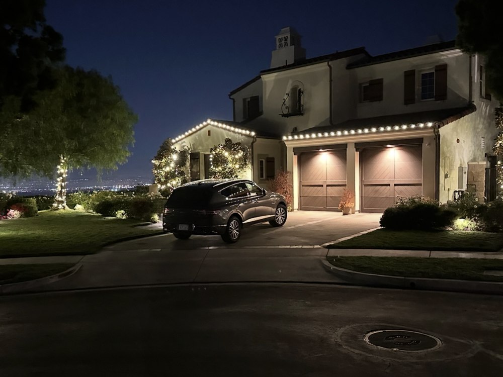 Hillside home with garage and tree lighting overlooking city view