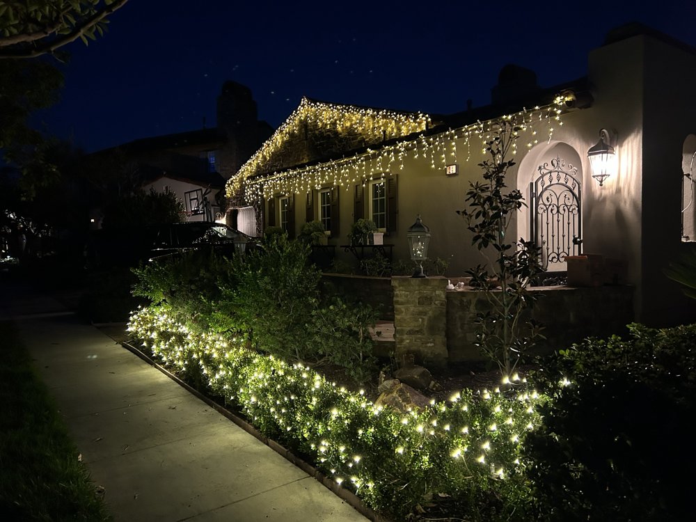Icicle lights and lit hedges along a walkway