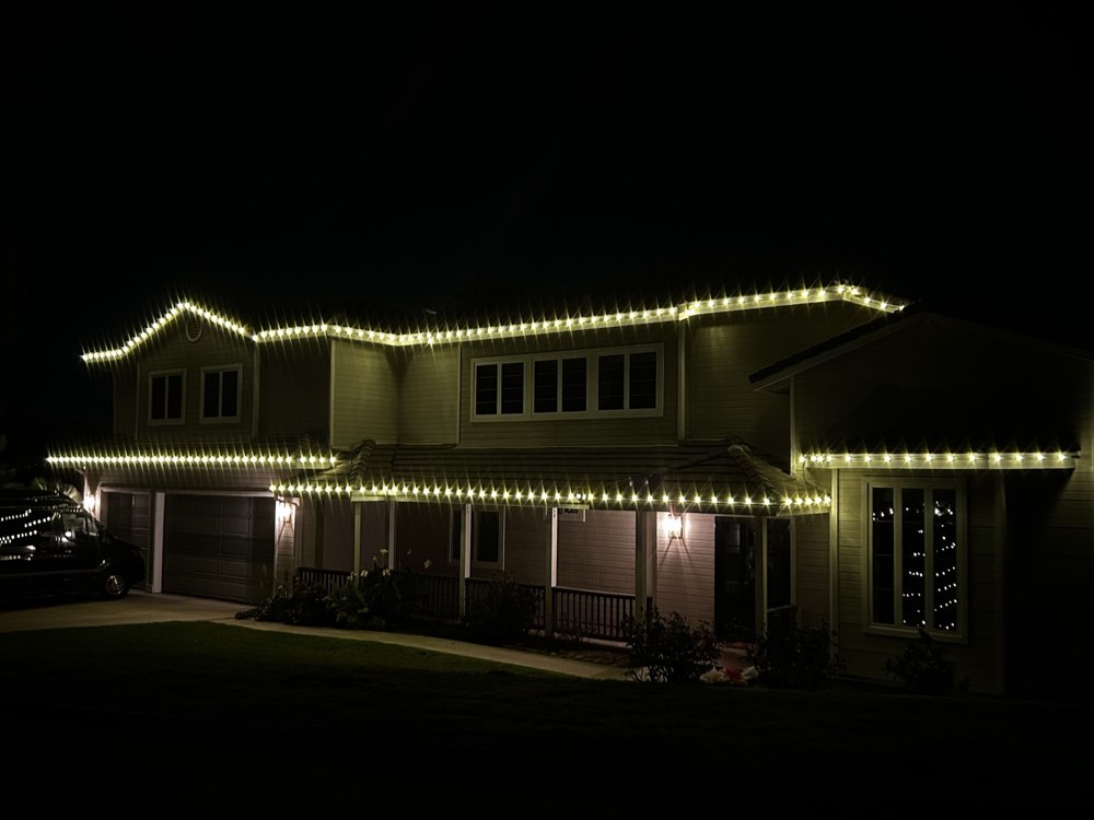 Home with covered porch and roofline lighting
